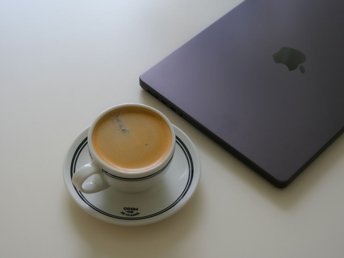 Espressotasse neben einem Laptop im Büro